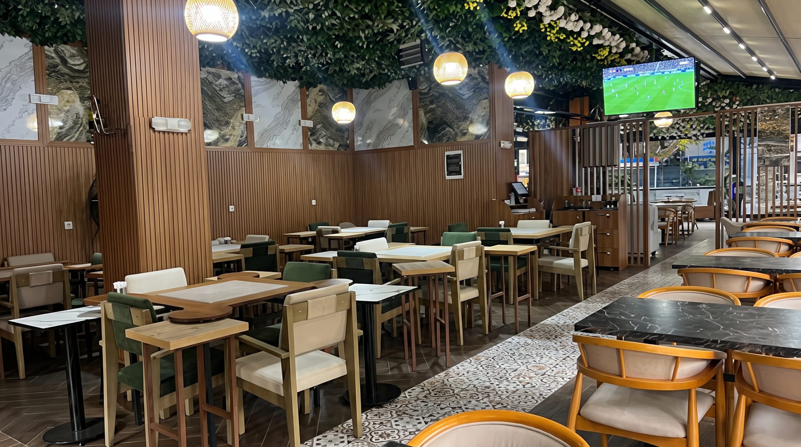 Holly Hola Coffee’de futbol akşamında maç yayını ekranı ve oturma alanı
